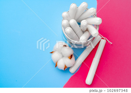 Female medical tampons on pink and blue background Female medical tampons on pink and blue background 102697348