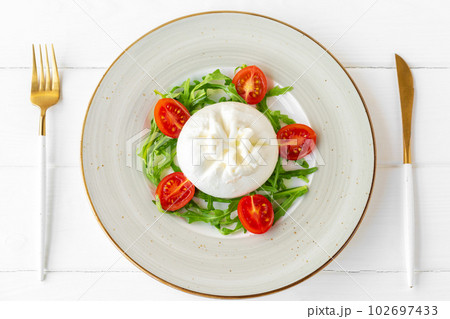 Salad with burrata cheese and cherry tomatoes on white wooden background 102697433