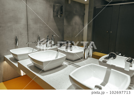 Public restroom with three sinks and mirror Public restroom with three sinks and mirror 102697713