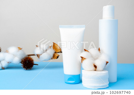 Cleansing gel and stack of cotton pads on paper background 102697740