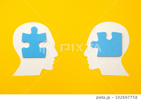 Papercut head silhouette with puzzle pieces on yellow background Papercut head silhouette with puzzle pieces on yellow background 102697758