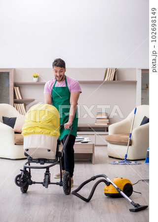 Young male contractor cleaner looking after newborn 102698149