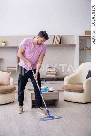 Young male contractor cleaning the house Young male contractor cleaning the house 102698170