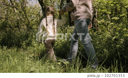 foot trail forest. mother child kid little girl. walk the feet of the forest. children's walk with a parent in the park. weekend vacation americans. chidhood dream. teamwork. pretty little girl. good. 102701353