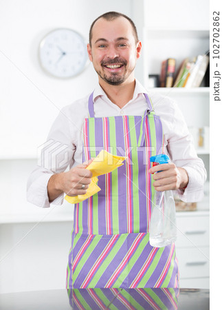 Young man in apron cleaning table Young man in apron cleaning table 102702862