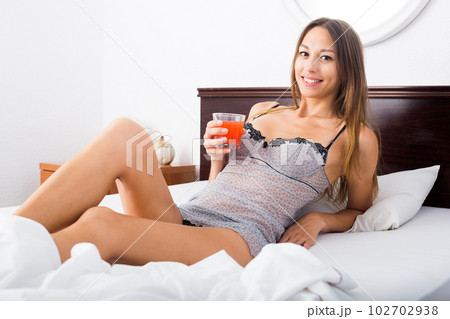woman drinking juice in bed 102702938