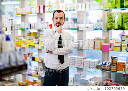 Smiling male customer looking for right medicine 102703629