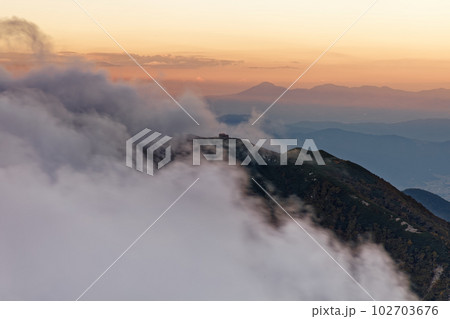中央アルプス・熊沢岳から見る雲流れる夕暮れの檜尾岳と蓼科山遠望 中央アルプス・熊沢岳から見る雲流れる夕暮れの檜尾岳と蓼科山遠望 102703676