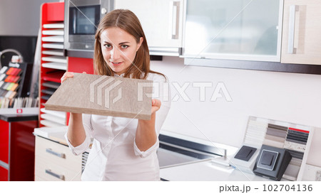 Woman choosing material for kitchen furniture 102704136