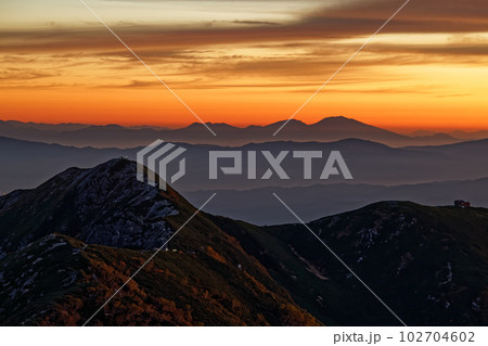 中央アルプス主稜線・熊沢岳から見る朝焼け雲と檜尾岳・浅間山 102704602