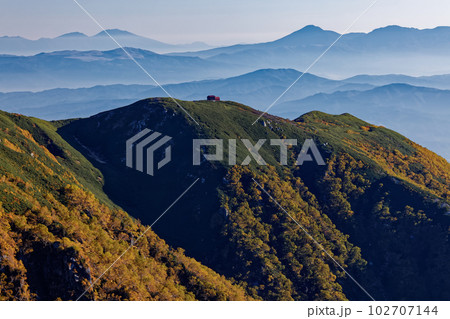 中央アルプス・熊沢岳から見る朝の檜尾岳避難小屋と蓼科山・浅間山 102707144