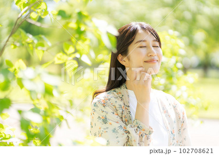 新緑の中で微笑む女性の写真 新緑の中で微笑む女性の写真 102708621