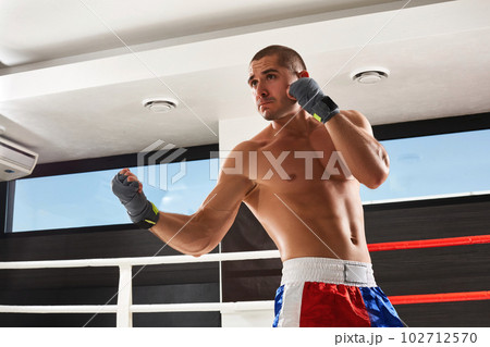 Boxer in blue gloves warming up in the gym Boxer in blue gloves warming up in the gym 102712570