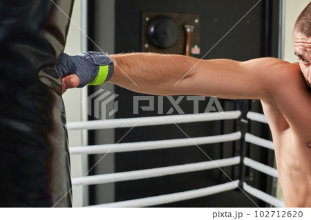 Young boxer training his skills hitting a punching bag. Young boxer training his skills hitting a punching bag. 102712620