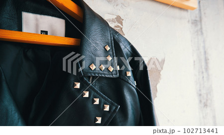 Close-up of leather jacket hanging on wooden hanger 102713441