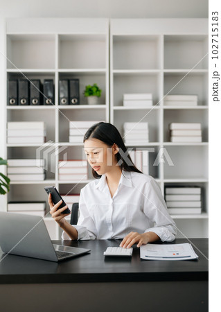Asian businesswoman working in the modern office with working notepad, tablet and laptop documents Asian businesswoman working in the modern office with working notepad, tablet and laptop documents 102715183