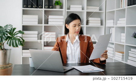 Business woman using tablet and laptop for doing math finance on an office desk, tax, report, accounting, statistics, and analytical research concept in office 102715419