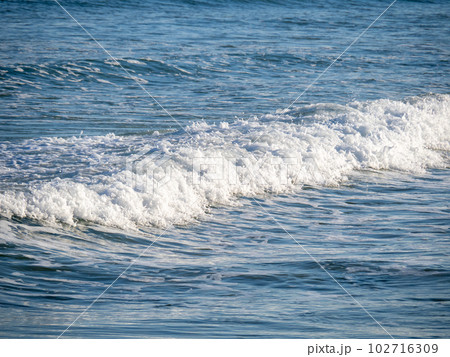 青い海から砂浜に打ち寄せる白波。 青い海から砂浜に打ち寄せる白波。 102716309