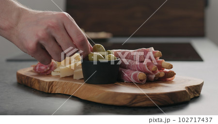 man hand take deli meals from olive wood board man hand take deli meals from olive wood board 102717437