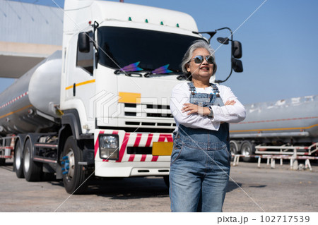 Business owner standing in front of oil truck after performing a pre-trip inspection on a truck. Concept of preventive maintenance. 102717539