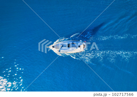 Wave and sail yacht on the sea as a background. .Sea and waves from top view. Blue water background Wave and sail yacht on the sea as a background. .Sea and waves from top view. Blue water background 102717566