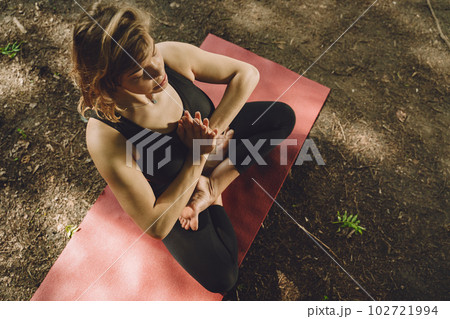 Pretty lady training in a summer park. Brunette doing yoga. Girl in a sportsuit. 102721994
