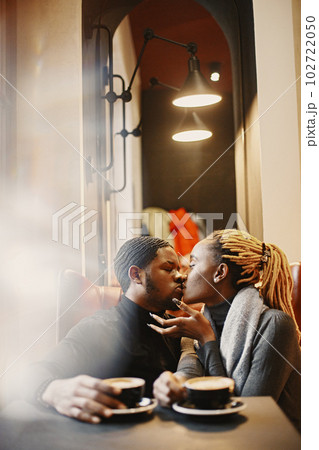 Two young people in cafe. African couple enjoying the time spending with each other. Two young people in cafe. African couple enjoying the time spending with each other. 102722050