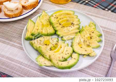 ripe avocado pulp cut into pieces sprinkled with lemon juice on a plate 102723093