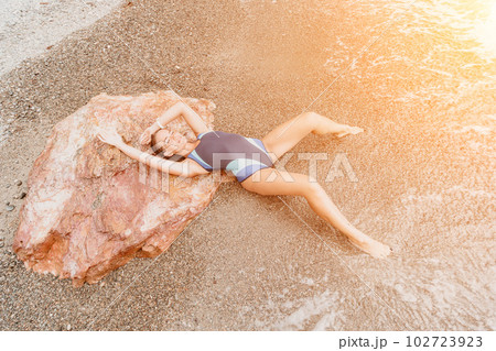Woman summer travel sea. Happy tourist in blue bikini enjoy taking picture outdoors for memories. Woman traveler posing on the beach surrounded by volcanic mountains, sharing travel adventure journey Woman summer travel sea. Happy tourist in blue bikini enjoy taking picture outdoors for memories. Woman traveler posing on the beach surrounded by volcanic mountains, sharing travel adventure journey 102723923
