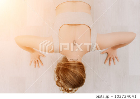 Young sporty woman, fitness instructor in sportswear doing stretching and pilates on yoga mat in the studio with mirror. Female fitness yoga routine concept. Healthy lifestyle and harmony. Young sporty woman, fitness instructor in sportswear doing stretching and pilates on yoga mat in the studio with mirror. Female fitness yoga routine concept. Healthy lifestyle and harmony. 102724041