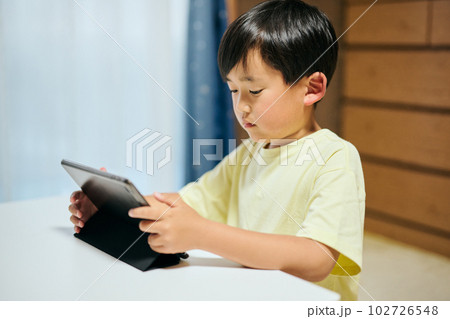 タブレットで動画を視聴する小学生の男の子 タブレットで動画を視聴する小学生の男の子 102726548