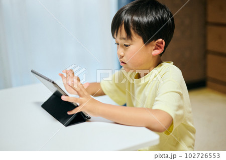 タブレットで動画を視聴する小学生の男の子 タブレットで動画を視聴する小学生の男の子 102726553