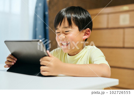 タブレットで動画を視聴する小学生の男の子 タブレットで動画を視聴する小学生の男の子 102726555