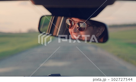 girl mirror interior car. portrait smile mirror. happy dream trip. female happy smile. drive a car road. taxi woman. road steering wheel. eyes mirror reflection. woman's face smile laugh. joy travel 102727544