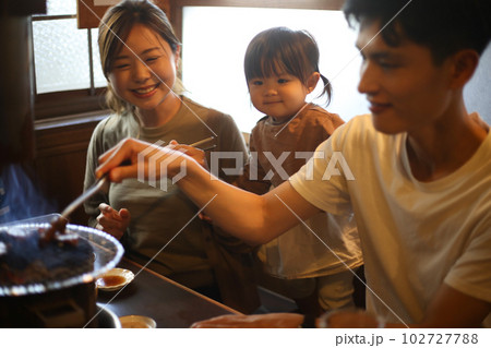 焼肉店で食事をする親子 102727788