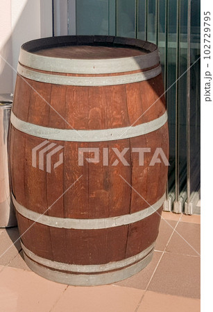 An old oak barrel stands at the entrance to a beer restaurant, shop, as an element of vintage design, vertical photo 102729795