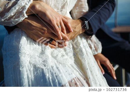 Bride and groom's hands with elegant wedding rings. Wedding details. Together. Wedding day. 102731736