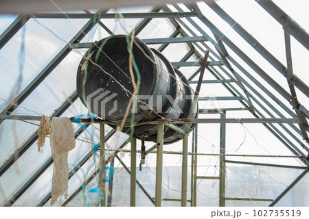 The water tank in the greenhouse is used to water the plants. 102735519