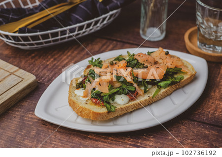 smoked salmon toast with sourdough and cheese. healthy mediterranean eating and diet. smoked salmon toast with sourdough and cheese. healthy mediterranean eating and diet. 102736192