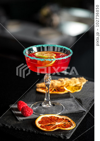 Rossini italian red alcoholic cocktail with sparkling wine, strawberry puree and ice in champagne glasses 102736850