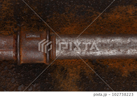 Rusty valve pipes on rusty metal wall 102738223