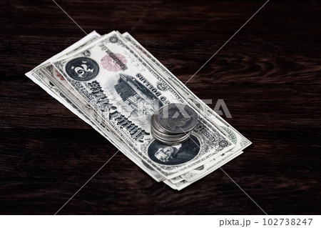 Old US banknotes and silver certificates with silver dollar coins 102738247