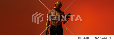 Sporty man performs exercises with expander on studio background. Strength and motivation Sporty man performs exercises with expander on studio background. Strength and motivation 102738814