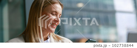 Cheerful businesswoman in jacket use phone during working in cafe. Distance work concept 102738844
