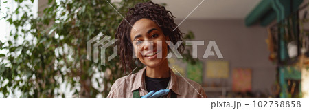 Portrait of smiling woman florist presenting beautiful floral composition with succulent plant 102738858