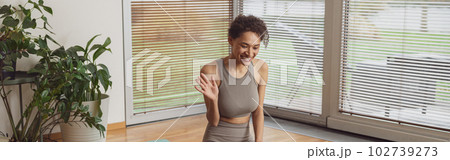 Afro american woman talking with fitness instructor by video call before online classes at home Afro american woman talking with fitness instructor by video call before online classes at home 102739273
