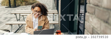 Afro american woman freelancer working remotely while sittiing on cafe terrace 102739510