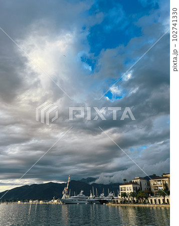 Marina with luxury yachts near the coast with expensive villas against the backdrop of mountains Marina with luxury yachts near the coast with expensive villas against the backdrop of mountains 102741330