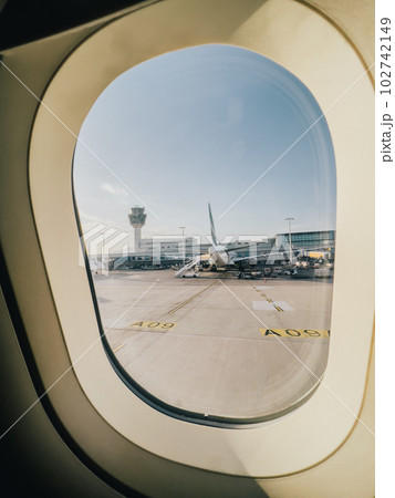 View from the porthole on a passenger plane standing in front of the airport building View from the porthole on a passenger plane standing in front of the airport building 102742149