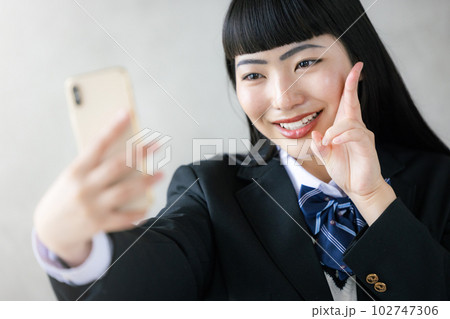 インカメで撮影する女子高生 102747306